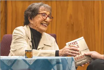  ?? Chris Torres/The Signal ?? Holocaust survivor and author Margot Webb speaks to the crowd about her new book, “Tears in the Eyes of My Enemy,” during the Yom Ha’Shoah Holocaust Remembranc­e Day event at Temple Beth Ami in Newhall on Thursday.
