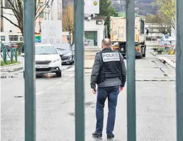  ??  ?? A French judicial police officer stands at the entrance to the 7th CBA de Reynies mountain infantry military barracks in Varces-Alliereset-Risset after a man tried to ram his car into soldiers jogging nearby. — AFP photo