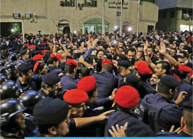  ?? — AFP ?? AMMAN: Demonstrat­ors face Jordanian anti-riot police and security forces during a protest in Amman, Jordan.