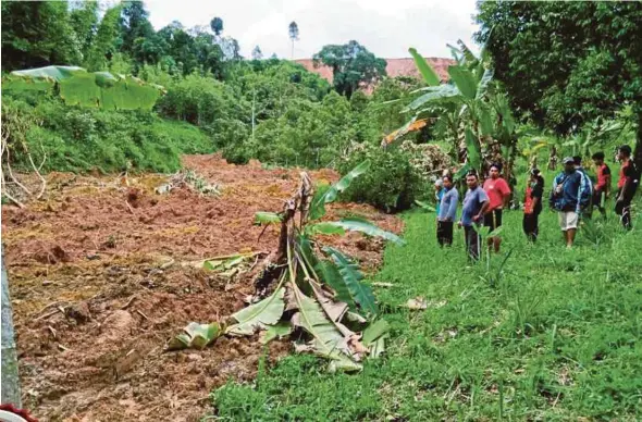  ?? FILE PIC ?? Orang Asli villagers looking at a tributary of Sungai Belatop that is covered by mud following a landslide in Kampung Sangwai, Lojing, Gua Musang, last month. The people fear another landslide may happen.