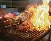  ??  ?? Felipe Riccio of Goodnight Charlie’s sears pork on a grill, one of the steps to making cochinita pibil.