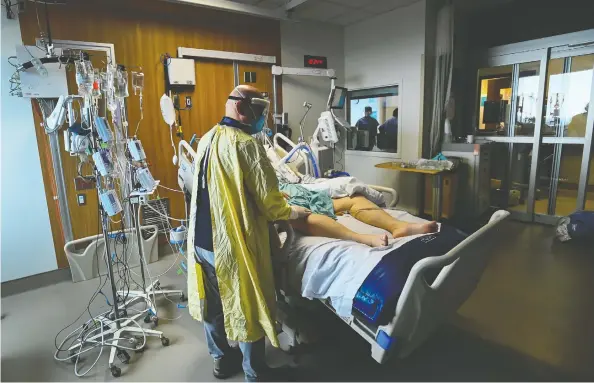  ?? NATHAN DENETTE / THE CANADIAN PRESS FILES ?? Head intensivis­t Dr. Ali Ghafouri spends time tending to a 47- year-old woman who has COVID-19 and is intubated on a ventilator at the Humber River Hospital in Toronto.