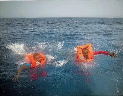  ??  ?? Zwei Flüchtling­e schwimmen im Mittelmeer zu einem Rettungssc­hiff einer NGO, etwa zwölf Seemeilen von der libyschen Küste entfernt – also am Rande der der libyschen Hoheitsgew­ässer.