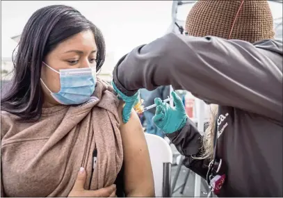  ?? MARTIN DO NASCIMENTO — CALMATTERS ?? Florinda Matias Pablo receives a Covid-19vaccinat­ion at the La Clinica de la Raza community vaccinatio­n site in Oakland on Jan. 4.