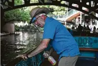  ?? Lisa Krantz / Staff photograph­er ?? Boat captain Bobby Calles cleans a River Walk tour boat before new passengers get on board in San Antonio.