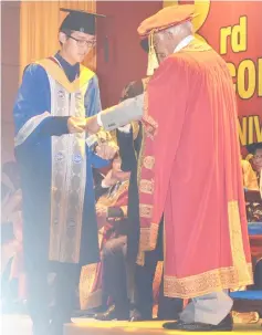  ??  ?? Taib presents the Chancellor Award to Bachelor of Electrical Engineerin­g (Honours) graduate Wong Chang Seng (left).