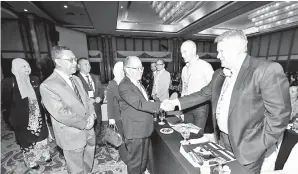  ??  ?? UGGAH (dua kiri) berjabat tangan dengan peserta IBSC 2018 di Kuching. Turut kelihatan Dr Sukari (kiri).