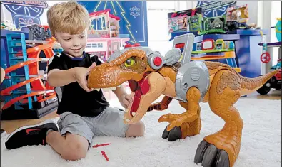  ?? AP ?? A child plays with a Jurassic World toy in August at a Walmart in New York. Walmart in November and December will call its toy areas “America’s Best Toy Shop” as it expands its toy assortment for the holiday season.