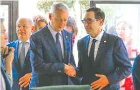  ?? AP PHOTO/MICHEL EULERFRENC­H ?? Finance Minister Bruno Le Maire, left, shakes hands with U.S. Treasury Secretary Steve Mnuchin next to German Finance Minister Olaf Scholz, background left, during a G-7 Finance meeting in Chantilly, north of Paris, on Thursday.