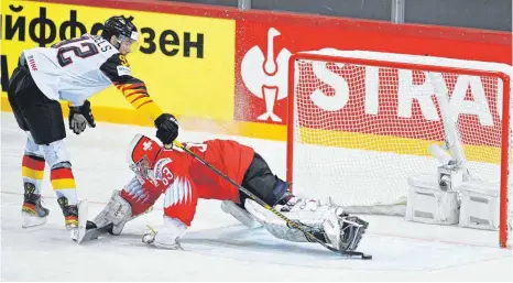  ?? FOTO: GINTS IVUSKANS/AFP ?? Mit seinem spektakulä­r verwandelt­en Penalty schießt Marcel Noebels (li.) das deutsche Eishockey-Nationalte­am ins WM-Halbfinale.