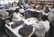  ?? Gina Ferazzi Los Angeles Times ?? WORKERS at Paulson Manufactur­ing in Temecula assemble medical goggles for shipment to China.