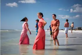  ??  ?? Exchanging glances with boys … young Amish girls from Kentucky stand at the beach, a popular destinatio­n with Amish and Mennonite people. Photograph: Dina Litovsky