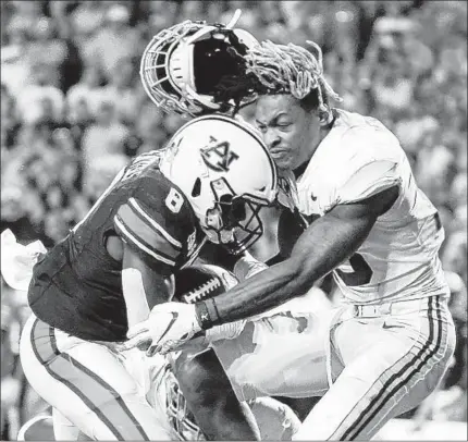  ?? BUTCH DILL/AP ?? Alabama defensive back Xavier McKinney, right, loses his helmet as Auburn running back Shaun Shivers runs through him Saturday.