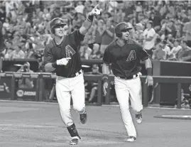  ?? RALPH FRESO/AP ?? The Diamondbac­ks' Jake Lamb (left, followed by teammate David Peralta) points to the crowd after his two-run home run against the Dodgers during the first inning Saturday.