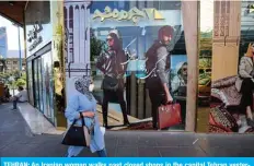  ??  ?? TEHRAN: An Iranian woman walks past closed shops in the capital Tehran yesterday. Iran charged yesterday that its arch-enemy Israel was behind an attack on its Natanz uranium enrichment plant and vowed it would take ‘revenge’.— AFP