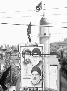 ??  ?? Portraits of Iranian-born Lebanese cleric Musa al-Sadr (top left), Iran’s Supreme Leader Ayatollah Ali Khamenei (top right) and Nasrallah, are seen outside a mosque in the southern Lebanese village of Kfar Sir. — AFP photo