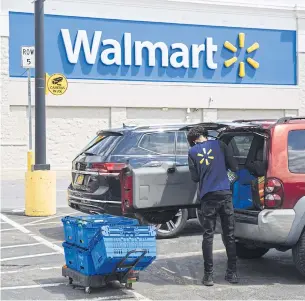  ??  ?? A worker delivers groceries to a customer’s vehicle outside a Walmart store in Amsterdam, New York on May 15.