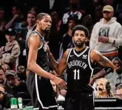  ?? Al Bello/TNS ?? The Brooklyn Nets’ Kevin Durant, left, and Kyrie Irving (11) look on in the final seconds of a 109-103 loss against the Boston Celtics during Game 3 of the Eastern Conference first-round playoff series on April 23 in New York.