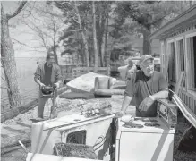  ??  ?? Left: Jim Woodman, right, leans on appliances destroyed by flooding while taking a break from emptying his family’s cottage with the help of his son, Mike, in Waterborou­gh, N.B.,