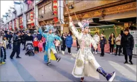  ?? WU CHENG / FOR CHINA DAILY ?? An opera performanc­e on a street of Huzhou, Zhejiang province, draws visitors on Jan 2.