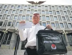 ??  ?? PEACE PLEA: A protester in a Trump mask holds a briefcase with a red button during a ‘stop the war’ demonstrat­ion outside the US Embassy in London, Aug 11, 2017.