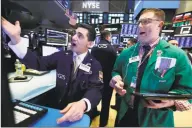  ?? Associated Press ?? Specialist Peter Mazza, left, and trader Ryan Falvey work on the floor of the New York Stock Exchange on Thursday.