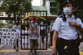  ?? Vincent Yu / Associated Press ?? A demonstrat­or stands behind a mock prison to protest a vote in Hong Kong that is limited to a select few people who have shown their loyalty to China.