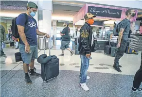  ?? SANDY HUFFAKER/ GETTY IMAGES ?? Passengers board a flight to Charlotte, N. C., at San Diego Internatio­nal Airport on Wednesday. Passenger counts are down more than 90% during the coronaviru­s pandemic.