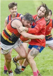  ??  ?? Glenn Browney tries to break away for his Longwarry side, with Lex Wright doing his best to stick the tackle in the wet this time last year.