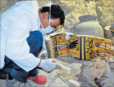  ?? Picture: AFP ?? STEP BACK IN TIME: An archaeolog­ist works on a wooden coffin in the Draa Abul Nagaa necropolis, near the southern Egyptian city of Luxor yesterday