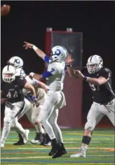  ?? PETE BANNAN — DIGITAL FIRST MEDIA ?? Quakertown quarterbac­k Brad Bryan, center, gets a pass off ahead of hard-charging Jaguar Cade Brennan, right, in the third quarter Friday night at Garnet Valley. The Jaguars advanced to the Class 6A district semifinals via a 49-14 victory.