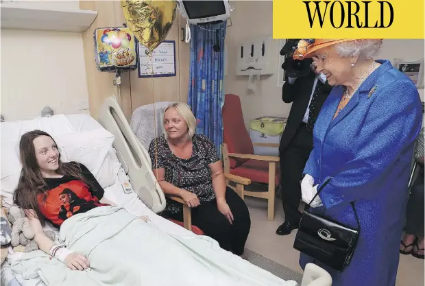  ?? PETER BYRNE / POOL VIA AP ?? Queen Elizabeth speaks to Millie Robson, 15, and her mother, Marie, during a visit Thursday by the British monarch to the Royal Manchester Children’s Hospital to meet victims of Monday’s terror attack in Manchester, and to thank members of staff who...