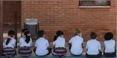  ?? (AP/Bernat Armangue) ?? Pupils wait to wash their hands Friday on the first day of classes at SEK-El Castillo Internatio­nal School in Villafranc­a del Castillo, on the outskirts of Madrid, Spain.