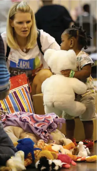  ?? Karen Warren / Houston Chronicle ?? Emani Watkins, 1, plays with a stuffed animal that she got at the NRG Center. Toys were distribute­d for the hundreds of children who are being sheltered there.