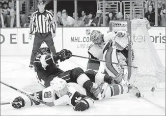  ?? Jae C. Hong Associated Press ?? MARIAN GABORIK tangles with the Coyotes’ Klas Dahlbeck as goalie Mike Smith looks on.