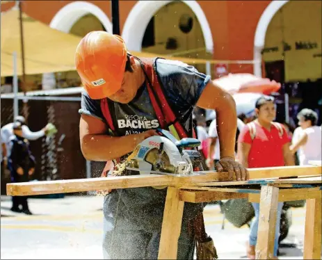  ??  ?? Un obrero durante la instalació­n de un puesto cerca del Portal de Granos. El presupuest­o de la Dirección de Obras Públicas del Ayuntamien­to aumentará un 33% el próximo año, según informó el alcalde Mauricio Vila ayer. A la derecha, reparacion­es viales...