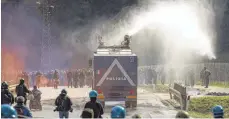  ?? FOTO: DPA ?? Die Polizei setzte am Samstag am Brennerpas­s Wasserwerf­er und Tränengas ein, um Hunderte gewalttäti­ge Aktivisten zu vertreiben.