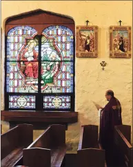  ?? Matthew Brown / Hearst Connecticu­t Media ?? The Rev. Jose Montoya stands before one of the Stations of the Cross at St. Benedict’s Church in Stamford.