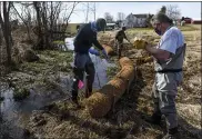  ?? BEN HASTY — MEDIANEWS GROUP ?? Trout unlimited members Jim Coffey, left, and Bob Young secure a coir log along the bank of the Valley Run Creek at Frontier Pastures, a farm in Washington Township.