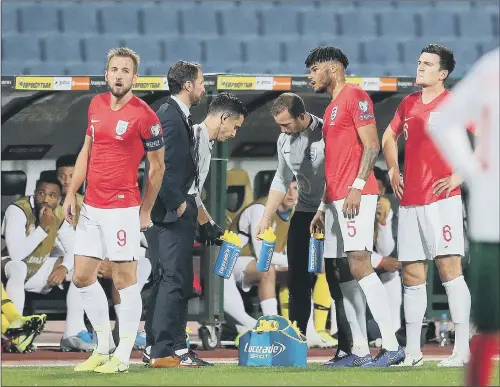  ?? PICTURE: CATHERINE IVILL/GETTY IMAGES. ?? CAPTION KICKER: England’s Tyrone Mings, second right, speaks with manager Gareth Southgate during a break in play during last night’s game.