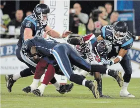  ?? RENE JOHNSTON TORONTO STAR FILE PHOTO ?? They’ve been here before as players and coaches. Mike O’Shea, left, and Orlondo Steinauer, right, team up for a tackle when both starred with the Toronto Argonauts, before joining the Tiger-Cats and then as head coaches of the Blue Bombers and Tiger-Cats.