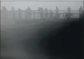  ??  ?? People at Lighthouse Point in Santa Cruz are enveloped in a thick fog on the morning of Jan. 5 as they check out the surf.