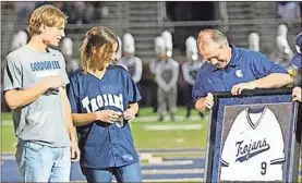  ??  ?? Former Gordon Lee pitcher Conard Broom is presented with a framed jersey as the Cleveland Indians farmhand was recently honored at halftime of a Trojans’ football game.