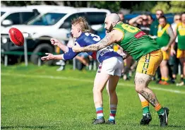  ?? Photograph­s by CRAIG JOHNSON. ?? Left: Newborough’s Will Troy gets his hands free for a handball release despite the tackle of Hill End’s Ryan Broberg in Saturday’s reserves game.
After a close first quarter, Newborough pulled away to win, 16.16-112 to 2.1-13.