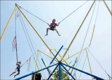  ?? Arkansas Democrat-gazette/staton BREIDENTHA­L ?? Catherine Justice (center), 6, of Little Rock and Katlynn Mccoy, 11, of Brinkley jump on the Quad Power jump attraction Sunday afternoon at Riverfest in downtown Little Rock.