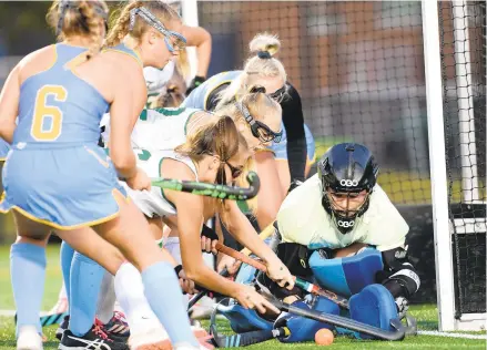  ?? COURTESY OF JOHN RADD ?? First Colonial goalkeeper Maddie George makes a save on a shot by Cox’s Zella Bailey as several players rush the net during a 2019 match at Powhatan Field in Norfolk. The Falcons are considered the team to beat this season.