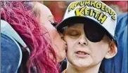  ?? JEFF LANGE / THE (AKRON) BEACON JOURNAL ?? Taylore Woodard kisses her son, Keith Burkett, after a Christmas parade held in his honor last month. Keith, 12, died on Monday.