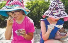  ?? Andy Cross, Denver Post file ?? Ice cream on a hot day? Of course. Lily Farnsworth and her sister Grace enjoy a cool treat at the 2017 Cherry Creek Arts Festival.