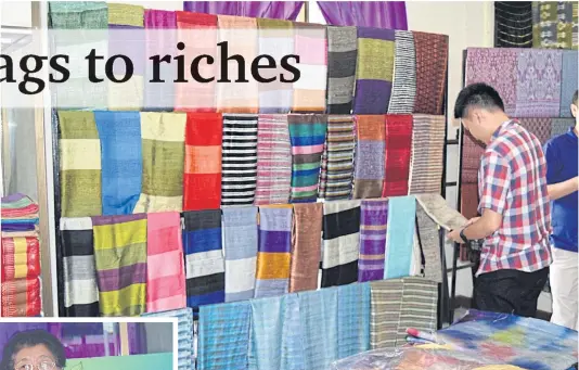  ??  ?? A visitor checks out handwoven fabric at Ban Na Pho.