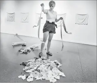  ?? Herald photo by Ian Martens ?? Artist Laura Ajayi drops strips of fabric into place preparing one of her pieces as part of her and artist April Matisz’s exhibit “Mommy, Mama, Mother, Mum” on display at Casa. @IMartensHe­rald